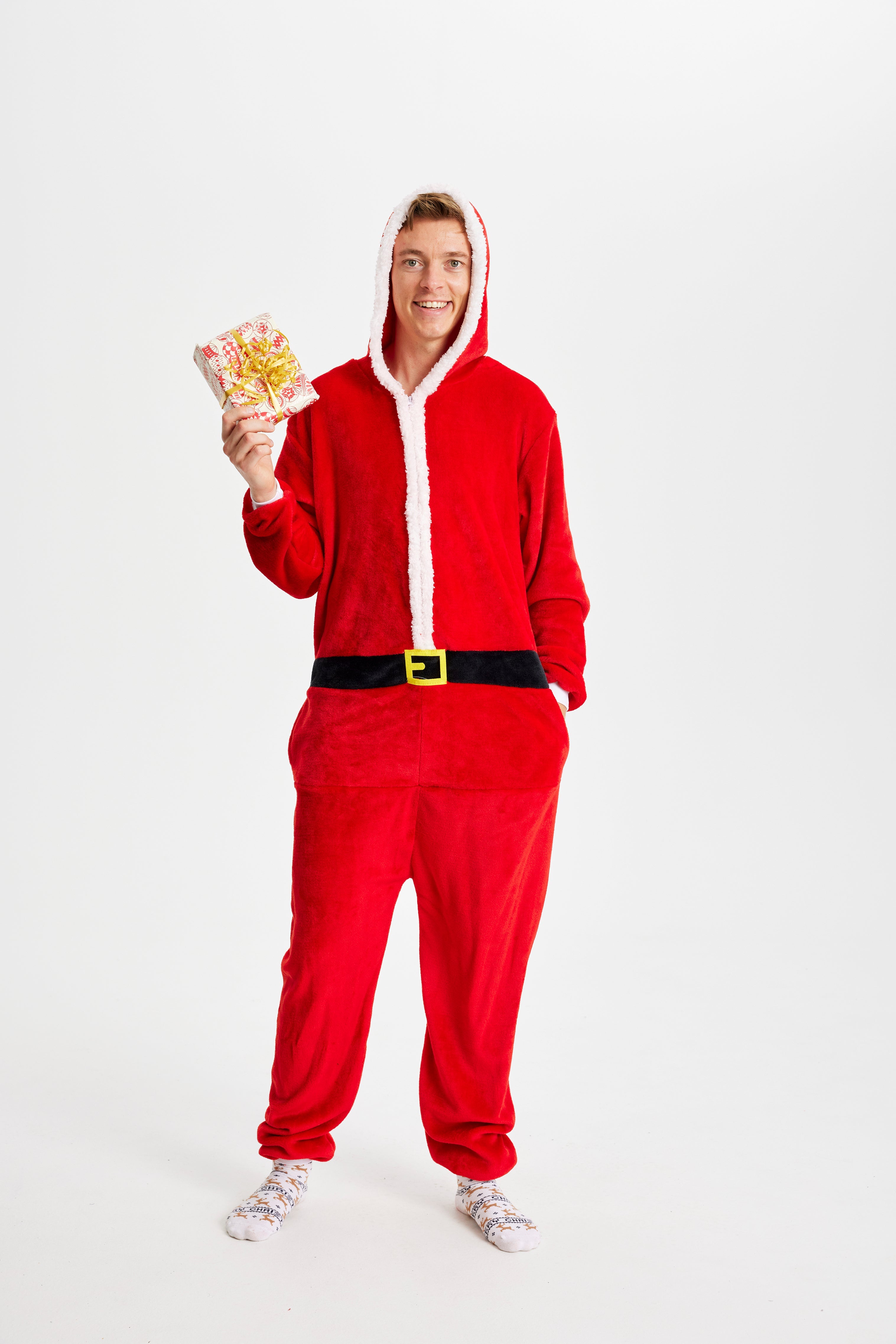 En mand med en gave i hånden iført en rød jumpsuit.